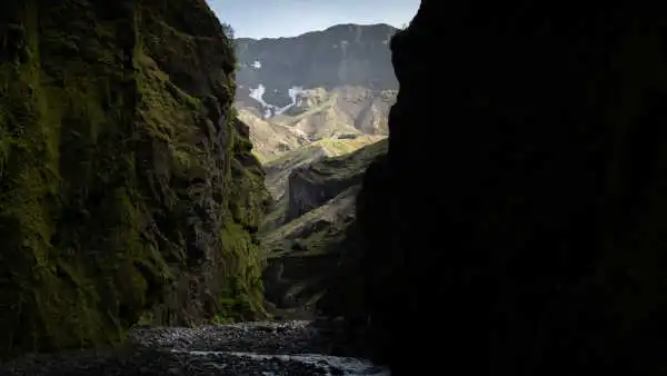 The end of a canyon is being lit by the sun, when the foreground is in the shade